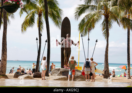 Touristen und Einheimische verlassen LEIS IN Hommage an der STATUE von DUKE PAOA KAHANAMOKU am Strand von Waikiki Stockfoto