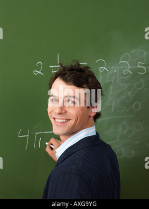 Lehrer schreiben an Tafel Stockfoto