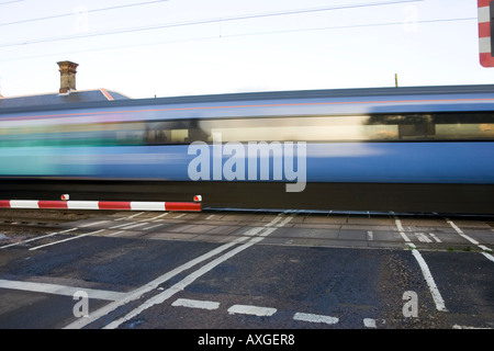 ein Schnellzug übergibt den Bahnübergang am Haughley in Suffolk UK Stockfoto