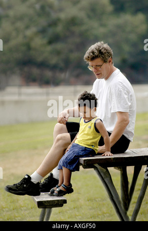 Vater mit schwarzen Adoptivsohn verbringen viel Zeit in einem öffentlichen park Stockfoto