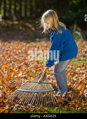 Kind Laubrechen in ihrem Hinterhof Stockfoto