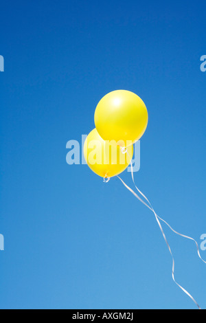 Zwei gelbe Luftballons in den Himmel Stockfoto