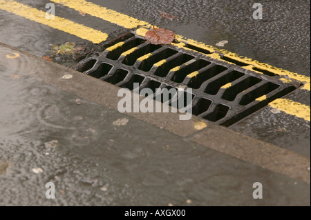 Wasser läuft in einen Abfluss an einem verregneten Tag Stockfoto