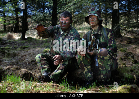 BRITISCHE ARMEE WEIBLICHE REKRUT HÖRT EINE EINWEISUNG DURCH EINE FARBE SERGEANT BEVOR STIELES AUSBILDUNG WÄHREND EINES SCHARFSCHÜTZEN KURS IN BRECO Stockfoto