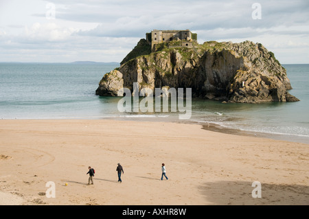 St. Catherine s Insel Südstrand Tenby Pembrokeshire Wales UK - drei Menschen zu Fuß am Sandstrand Stockfoto