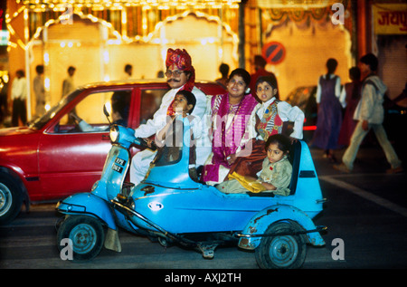 Hindu Familienausflug zusammengepfercht auf kleinen Motorroller feiern in der Nacht beim Festival von Diwali in Jaipur Rajasthan, Indien Stockfoto