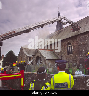 Feuerwehrleute, die Dachziegel zu entfernen, wie sie eine Kirche Brandgefahr durch Kleinkinder an der St. Brannocks Kirche Braunton Devon England angehen Stockfoto