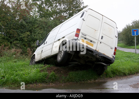 Ein weißer Lieferwagen stürzte in einen Graben. Stockfoto