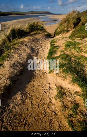 Bahnen entlang der Küsten Fußweg und Dünen mit Blick auf eine Mündung an der Küste von North Cornwall. Stockfoto