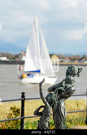Die Skulptur Willkommen zu Hause von Anita Lafford auf Fleetwood Promenade mit ankommenden Yacht im Hintergrund