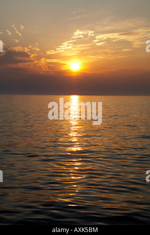 Abendsonne mit farbigen Wolken reflektiert Sonnenlicht im Wasser des Meeres von Saronida in Attika oder Atiki Griechenland Stockfoto