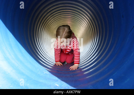 Mädchen, die durch Tunnel kriechen Stockfoto