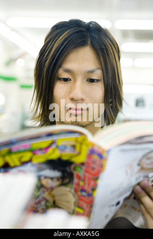 Junger Mann im Manga-Stil Comic-Buch zu lesen Stockfoto