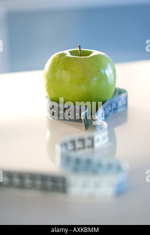 Grüner Apfel mit Maßband um ihn herum, Nahaufnahme Stockfoto