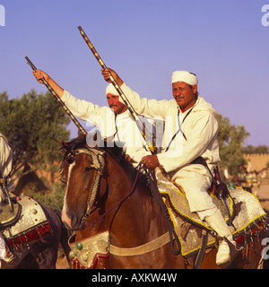 Zwei Berber Reiter sitzen auf verzierten silbernen mit Filigran geschmückten Sättel in traditionellen langen weißen Roben & Stirnbänder Marrakesch Marokko Stockfoto