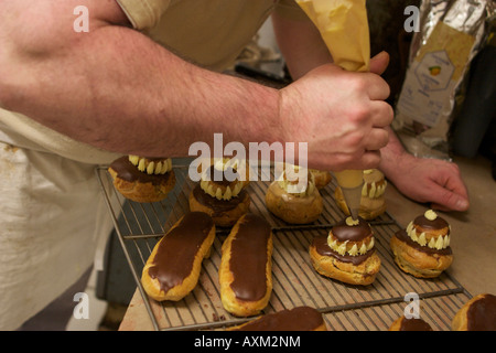 Baker Jacques Langlois Anwendung Creme Religieuse Gebäck in seiner Bäckerei auf der rue Laufe in Rouen, Seine-Maritime, Frankreich. Stockfoto