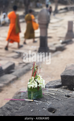 Angebote im Wat Phu Champasak mit Mönchen im Hintergrund Stockfoto