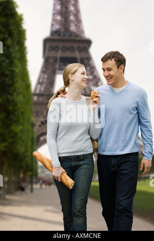 Paare, die mit Eiffelturm im Hintergrund Stockfoto