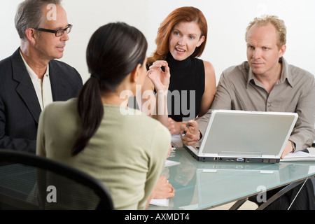 Geschäftsleute sprechen um laptop Stockfoto