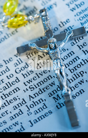 Nahaufnahme eines Kruzifix mit Rosenkranz auf Bibel Stockfoto