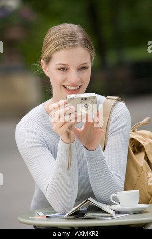 Frau mit Digitalkamera in Straßencafé Stockfoto