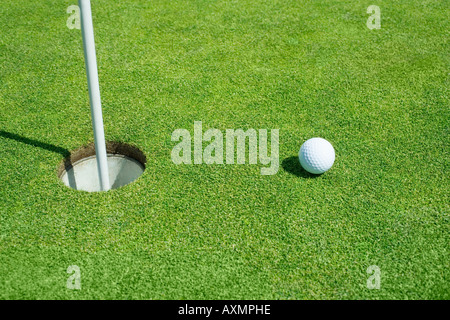 Golfball in der Nähe von Cup am Putting Green im freien Stockfoto