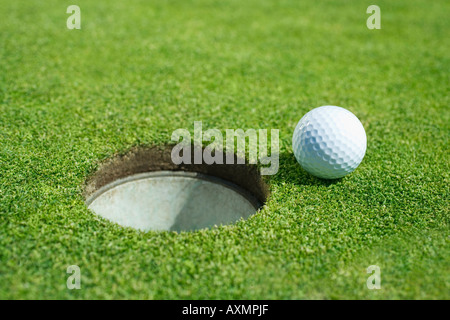 Golfball in der Nähe von Cup am Putting Green im freien Stockfoto