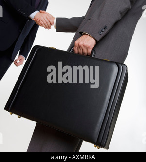 Geschäftsmann mit Aktenkoffer Händeschütteln Stockfoto