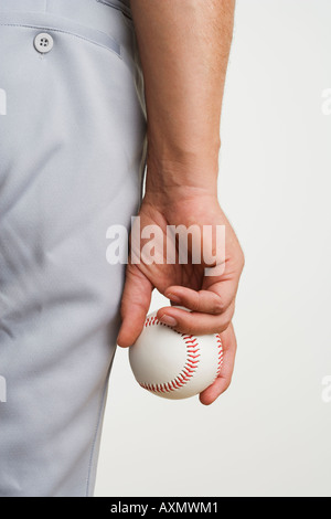 Der Mann hält Baseball seitlich hautnah Stockfoto