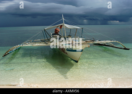 Bangka oder traditionelle philippinische Boot ruht in Küstennähe, während Sturm nähert sich Malapascua, Cebu, Philippinen Stockfoto