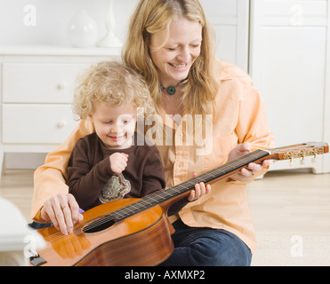 Mutter und Kind spielt mit Gitarre Stockfoto