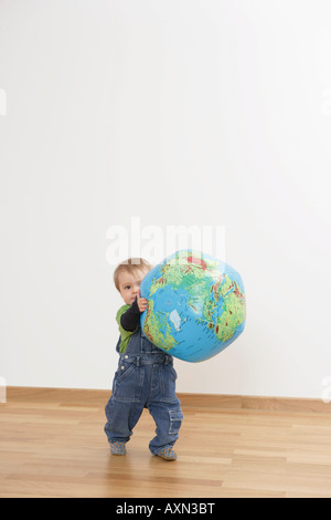 Baby Junge hält einen Globus Stockfoto