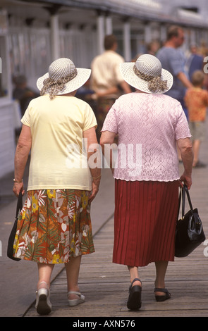 Identische Zwillinge, Rückansicht zwei ältere Frauen tragen Hüte mit langen Röcken und Handtaschen Brighton East Sussex UK 2001 2000s HOMER SYKES Stockfoto