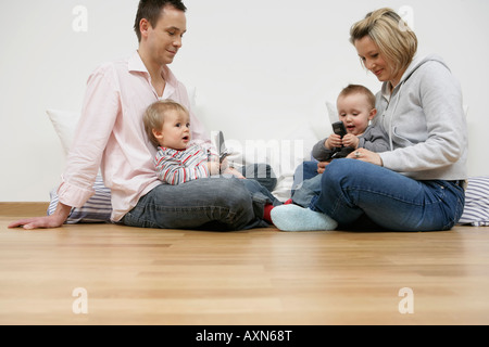 Mutter und Vater sitzen gegenüber, Söhne spielen mit Mobiltelefonen Stockfoto