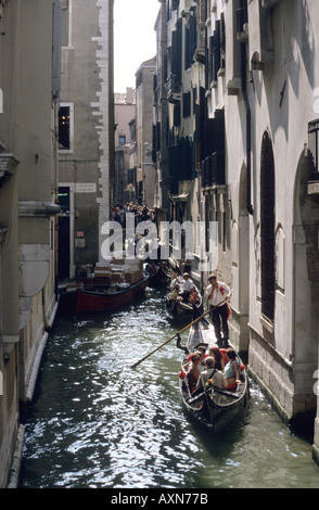 Touristen genießen eine Fahrt mit einer Gondel durch die Kanäle in Venedig, Italien. Stockfoto