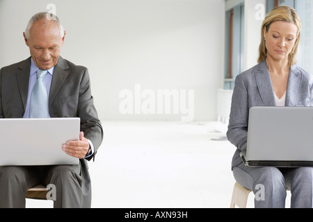 Ältere Manager und Business-Frau sitzen nebeneinander, Laptop auf den Knien Stockfoto