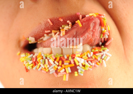 Nahaufnahme von Frau Lippen fallenden Süßigkeiten Stockfoto