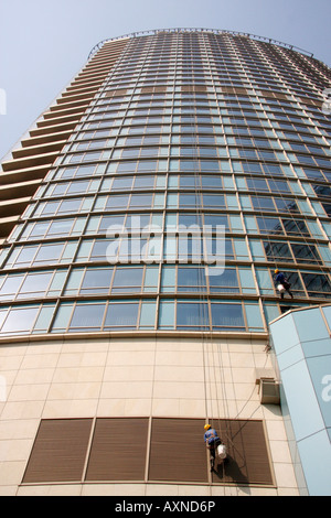 Fensterputzer bei Arbeiten auf die Weite des Glases an der Fassade des neuen Hochhaus Hyatt über the Bund Hotel, Shanghai, China Stockfoto