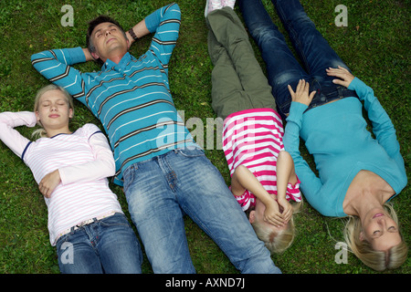 Familie mit zwei Kindern auf einer Wiese, erhöhte Ansicht liegend Stockfoto