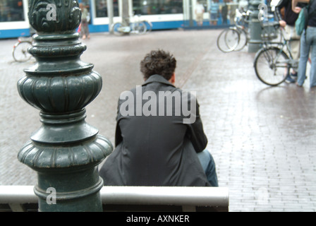 Mann auf einer Bank, Blick auf Fahrräder in Amsterdam Stockfoto