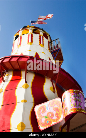 Altmodische rot gestreiften stripey durcheinander Helter Skelter Folie Holz mit Flagge unter blauem Himmel Stockfoto