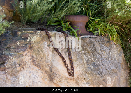 Ein Gusseisen-Poller Sandstein an Blues-Punkt und ein kurzes Stück rostigen Kette befestigt. Stockfoto