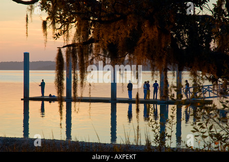 Gruppe von Touristen und einsamen Fischer stehen auf Promenade während des Sonnenuntergangs in der Nähe von Hilton head South Carolina Vereinigte Staaten von Amerika Stockfoto