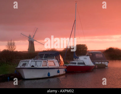 Thurne Deich mit Vergnügen Kreuzer mit Mühle im Hintergrund, Sonnenuntergang, Norfolk Broads, England, Vereinigtes Königreich, Stockfoto