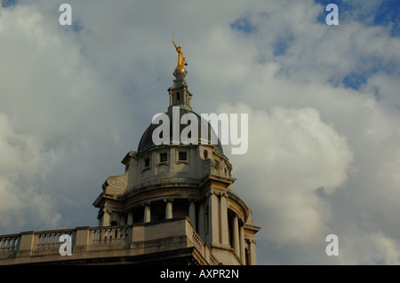 Die Statue der Gerechtigkeit in der Kuppel des Old Bailey glänzt in der Sonne mit einem dramatischen bewölkten Himmel im Hintergrund. Stockfoto