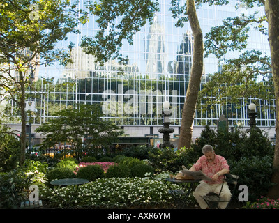 Ein Mann liest Zeitung im Bryant Park, New York City USA Stockfoto