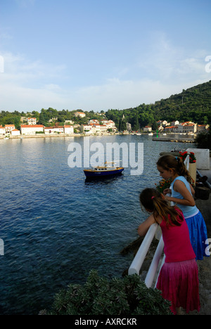 Zwei Kinder, stützte sich auf Schiene, Blick auf Hafen, Dorf Racisce, Insel Korcula, Kroatien Stockfoto