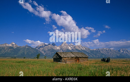 Ein Blick auf eine alte Scheune und den hoch aufragenden Gipfeln auf den Grand Teton im Grand Teton National Park in der Nähe von Jackson Hole Stockfoto