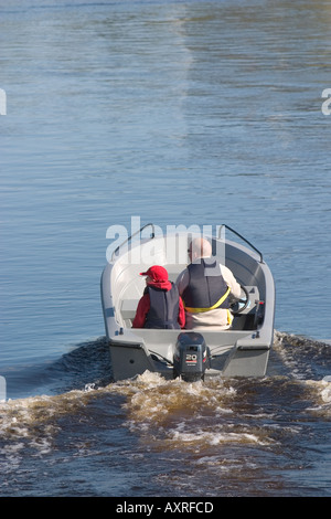 Vater und Sohn fahren in einem Motorboot / Schiff am Oulujoki Fluss Finnland Stockfoto