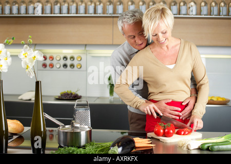 Blonde Frau und grauhaarige Mann gemeinsam kochen Stockfoto